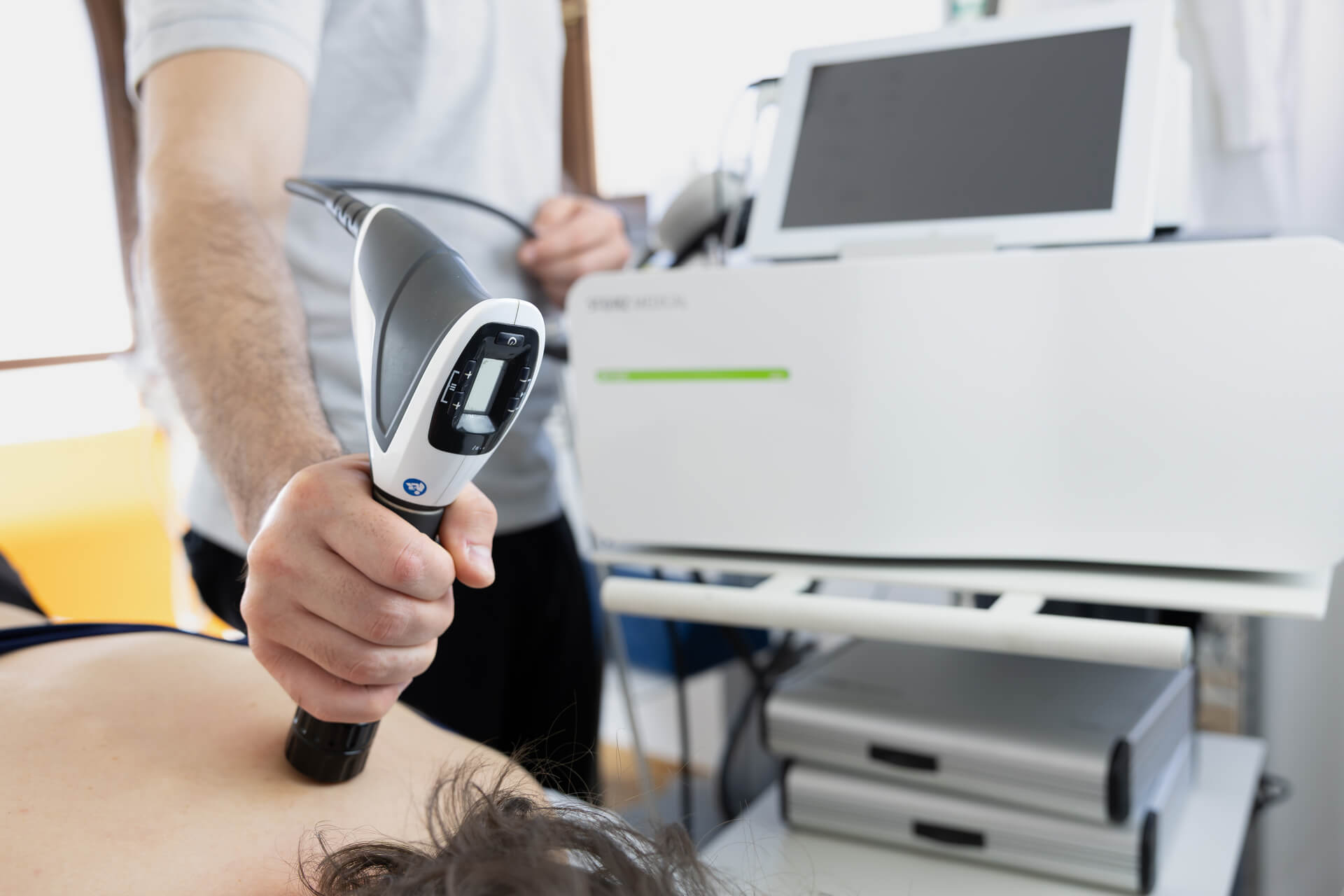 Dettaglio del dispositivo per onde d'urto durante applicazione terapeutica sulla schiena