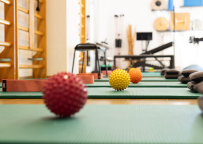 Palline propriocettive colorate ed elastici su tappetini nella sala di fisioterapia