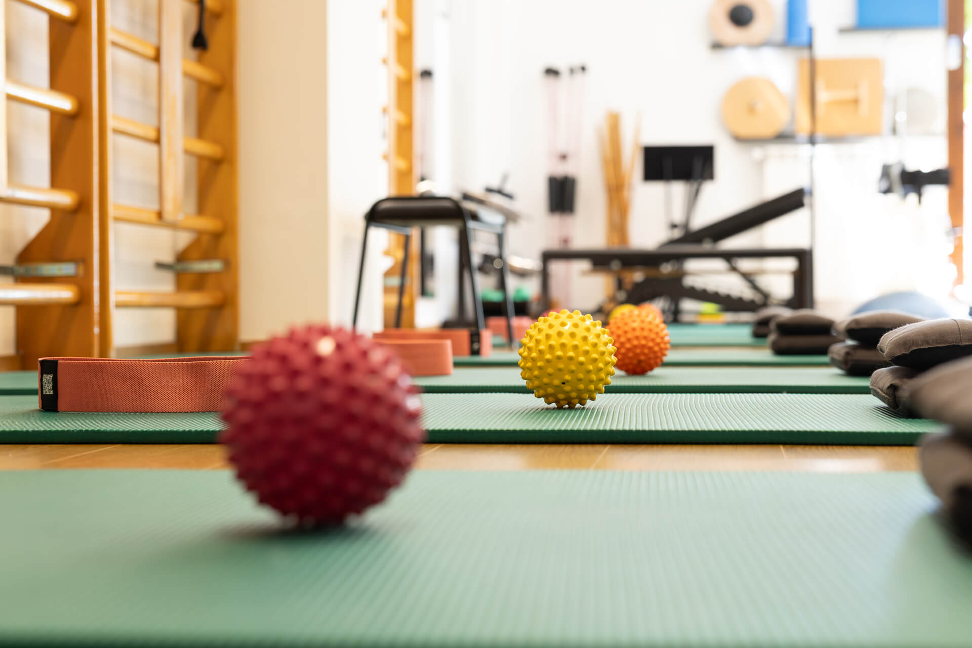 Palline propriocettive colorate ed elastici su tappetini nella sala di fisioterapia