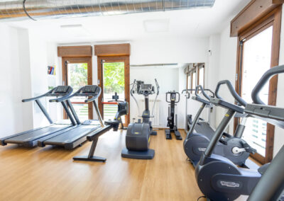 Attrezzature Technogym, tapis roulant e cyclette nella sala fitness del poliambulatorio