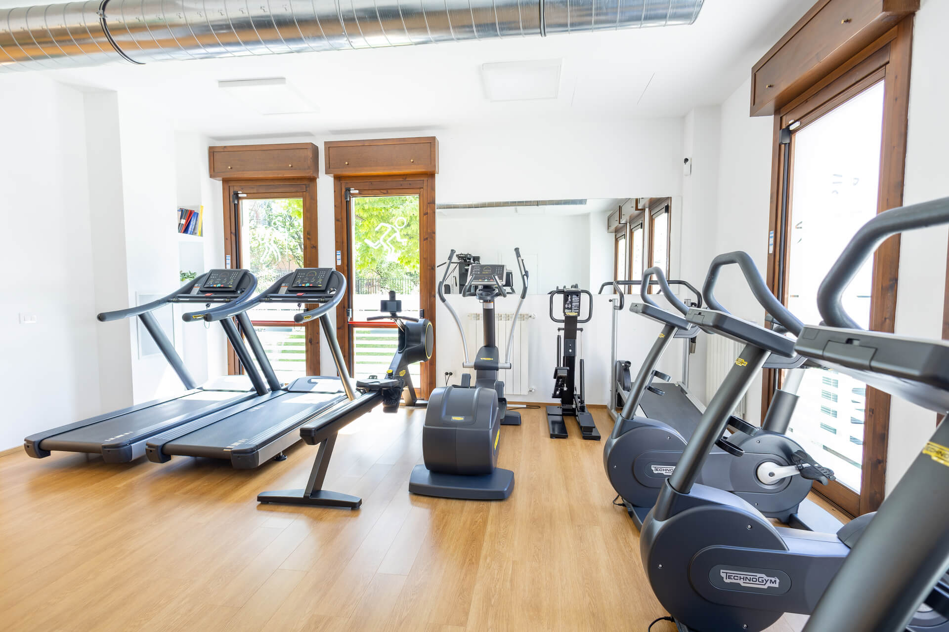 Attrezzature Technogym, tapis roulant e cyclette nella sala fitness del poliambulatorio